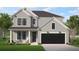 Charming two-story home features a black garage door, stylish black window frames, and a well-manicured lawn at 8629 Connor Ct, North Charleston, SC 29406