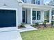 Close up of a new home with a black garage door, black trim windows, and a green front lawn at 8629 Connor Ct, North Charleston, SC 29406