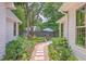 Landscaped backyard featuring stone path, lush green lawn, seating, and white picket fence at 974 Cliffwood Dr, Mount Pleasant, SC 29464