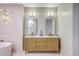 Well-lit bathroom featuring a wooden vanity with double sinks, gold fixtures, and a modern soaker tub at 974 Cliffwood Dr, Mount Pleasant, SC 29464