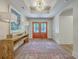 A stylish foyer with a wooden console table, elegant lamps, beautiful rug, and a striking chandelier, creating an inviting ambiance at 974 Cliffwood Dr, Mount Pleasant, SC 29464