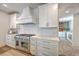 Bright kitchen boasts white cabinets, marble countertops, a stainless steel stove, and stylish backsplash at 974 Cliffwood Dr, Mount Pleasant, SC 29464