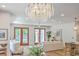Elegant living room with hardwood floors, modern chandelier, and outdoor access via wooden-framed glass doors at 974 Cliffwood Dr, Mount Pleasant, SC 29464