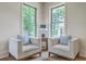 Cozy sitting area featuring two armchairs with blue pillows, hardwood floors, and a bright view of the yard at 974 Cliffwood Dr, Mount Pleasant, SC 29464