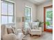 Cozy sitting room featuring two white armchairs, stylish lamps, and a view of the outdoor garden and patio at 974 Cliffwood Dr, Mount Pleasant, SC 29464