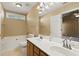 Bathroom with double sink vanity, large soaking tub, and a window for natural light at 103 Case Ct, Ladson, SC 29456