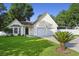 Charming single-Gathering home featuring an attached two-car garage, well-maintained lawn, and a mature palm tree at 103 Case Ct, Ladson, SC 29456