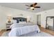 A cozy bedroom features a ceiling fan, wood floors, and a bed with decorative pillows next to a mirror at 105 Conductor Ct, Summerville, SC 29486