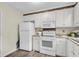 Bright kitchen featuring white cabinets, appliances, and ample counter space at 105 Conductor Ct, Summerville, SC 29486