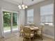Bright dining area with wood floors and a table with four chairs next to a glass sliding door to the backyard at 1069 Lexi Ct, Ladson, SC 29456