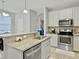 Well-lit kitchen featuring granite countertops, stainless appliances, and access to the staircase at 1069 Lexi Ct, Ladson, SC 29456