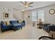 Inviting living room with a plush blue sectional sofa, a ceiling fan, staircase, and window with blinds at 1069 Lexi Ct, Ladson, SC 29456