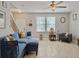 Inviting living room with a plush blue sectional sofa, a ceiling fan, staircase, and window with blinds at 1069 Lexi Ct, Ladson, SC 29456