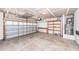 A two car garage with a partially open door and storage shelves at 107 Brookhaven Rd, Summerville, SC 29486
