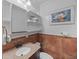 Bathroom featuring granite countertop, bronze faucet and fixtures, open shelving, and fish art at 11 America St, Charleston, SC 29403