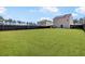 Large backyard with healthy green grass, a privacy fence, and a view of the house at 110 Cardinal Flower Ct, Moncks Corner, SC 29461