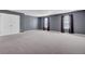 Spacious bonus room with neutral carpet, gray walls, windows with drapes, and a closet with double doors at 110 Cardinal Flower Ct, Moncks Corner, SC 29461
