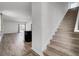 View of the living room with natural light, hardwood floors, and an open staircase at 110 Cardinal Flower Ct, Moncks Corner, SC 29461