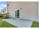 Back patio with sliding glass doors that lead to the house, a small bush, and green grass at 110 Cardinal Flower Ct, Moncks Corner, SC 29461