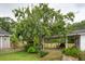 Large backyard with mature trees, a covered patio area, and a quaint picket fence at 1121 Armstrong Ave, Charleston, SC 29407