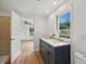 Bathroom featuring dual sinks with marble counters, a shower, and a large window at 1121 Armstrong Ave, Charleston, SC 29407