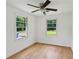 Bright bedroom with hardwood floors, ceiling fan and two windows with natural light at 1121 Armstrong Ave, Charleston, SC 29407