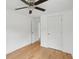Bright bedroom with hardwood floors, ceiling fan, closet, and doorways visible at 1121 Armstrong Ave, Charleston, SC 29407