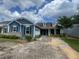 Charming blue home featuring a welcoming front porch, dormer windows, and landscaped yard with beautiful blue sky at 118 Magnolia House Dr, Summerville, SC 29486