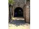 Gated entrance to a brick townhouse featuring an arched entrance with an intricate black iron gate at 128 Queen St, Charleston, SC 29401