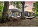 Relaxing backyard featuring mature trees, a hammock, and a wood deck, perfect for outdoor living at 1309 Llewellyn Rd, Mount Pleasant, SC 29464