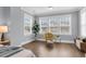 Sunlit bedroom featuring hardwood floors, large windows, and a comfortable seating area with modern decor at 1392 Founders Way, Mount Pleasant, SC 29464
