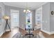 Bright dining area featuring a glass table, chandelier, and natural light from multiple windows at 1392 Founders Way, Mount Pleasant, SC 29464
