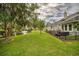 Exterior view of home and backyard with water feature, green grass, grill and seating area at 15 A Par Dr # 27, Charleston, SC 29414
