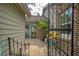 View through the decorative metal gate into an enclosed courtyard with brick and cement pavers at 15 A Par Dr # 27, Charleston, SC 29414