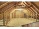 Unfinished attic space with wooden beams, plywood flooring and white insulation at 154 Patrick Ln, Summerville, SC 29483