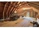 Unfinished attic space featuring wooden beams, a window, and plywood flooring at 154 Patrick Ln, Summerville, SC 29483