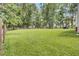Large backyard with green lawn and mature trees, offering a private and spacious area for outdoor enjoyment and leisure at 154 Patrick Ln, Summerville, SC 29483