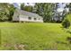 Expansive backyard showcasing a well-maintained lawn, bordered by mature trees and a house with a brick foundation at 154 Patrick Ln, Summerville, SC 29483