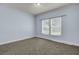 A carpeted bedroom with light blue walls and a window with blinds at 154 Patrick Ln, Summerville, SC 29483