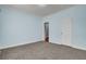 Carpeted bedroom with light blue walls, white trim, and a closed white door at 154 Patrick Ln, Summerville, SC 29483