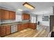 Eat-in kitchen boasts wood cabinets, tile countertops, stainless steel appliances, and modern wood-look flooring at 154 Patrick Ln, Summerville, SC 29483