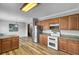 Traditional kitchen with wood cabinets, tile countertops, and stainless steel appliances opens to eat-in area at 154 Patrick Ln, Summerville, SC 29483