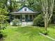 Charming bungalow-style home with a cozy front porch and verdant lawn surrounded by mature trees at 1640 Dogwood Rd, Charleston, SC 29414