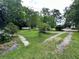 Front yard with a mix of gravel and grass leading to a home on a treed lot at 1640 Dogwood Rd, Charleston, SC 29414