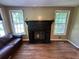 Living room boasts a classic fireplace flanked by bright windows and gleaming hardwood floors at 1640 Dogwood Rd, Charleston, SC 29414