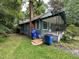 The house features a brick chimney and an inviting porch, surrounded by a spacious lawn and mature trees at 1640 Dogwood Rd, Charleston, SC 29414