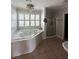 Bathroom with a large tub under a window, a glass shower, and neutral tiling at 1866 Capri Dr, Charleston, SC 29407
