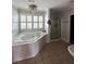 Luxurious bathroom featuring a large soaking tub, tiled floors, and a separate shower at 1866 Capri Dr, Charleston, SC 29407
