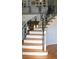 Staircase with wooden steps, white risers, and decorative black iron railing at 1866 Capri Dr, Charleston, SC 29407