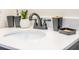 Close-up of the clean white bathroom sink and countertop with a modern dark faucet and bathroom accessories at 2172 Palermo Pl, North Charleston, SC 29406